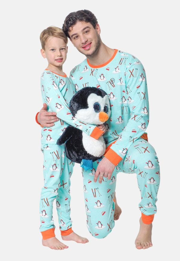 Vader en zoon dragen dezelfde blauwe pyjama, en zoon heeft een leuke pinguïn knuffel vast