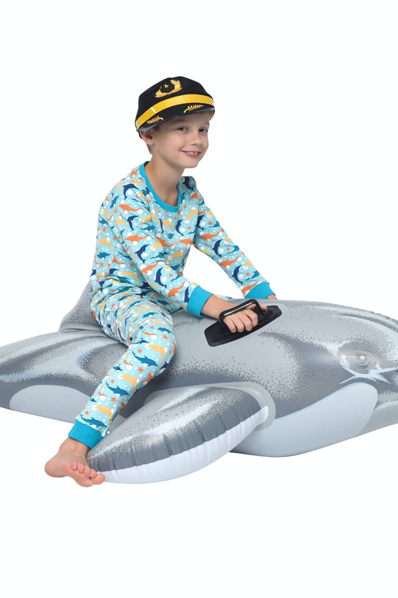 In een jongenspyjama op een opblaas dolfijn