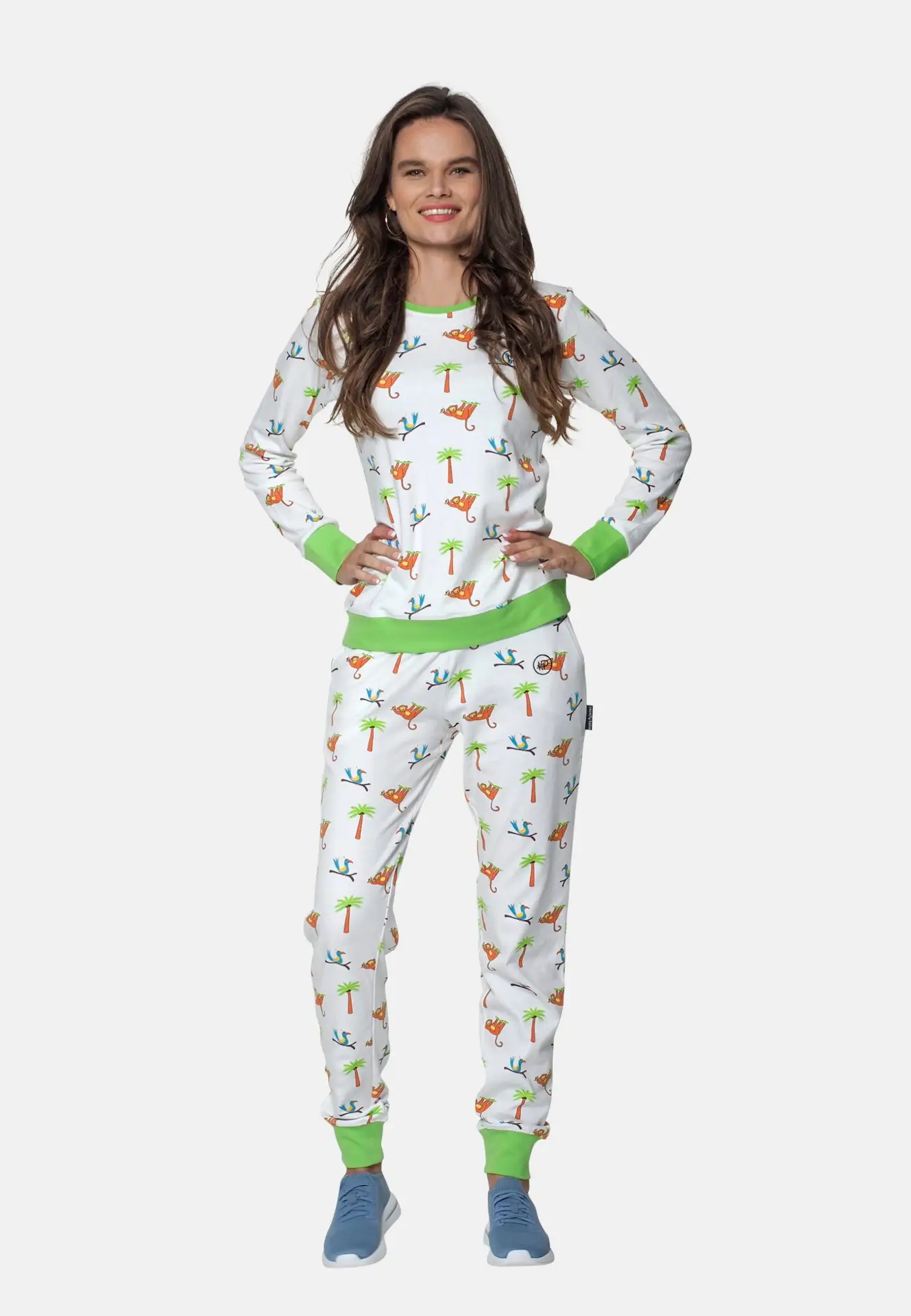 Witte dames pyjama met print, en groene elastische banden. Pyjama met apen en palmbomen