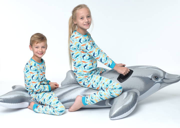 Meisje en jongen in een happy pyjama kinderpyjama op een opblaas dolfijn