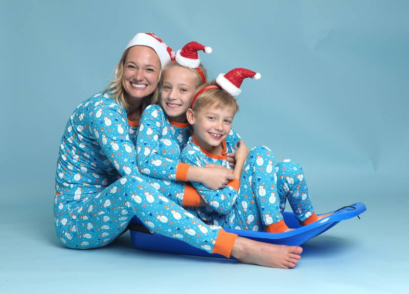 Moeder met zoon en dochter in een blauwe pyjama op een slee