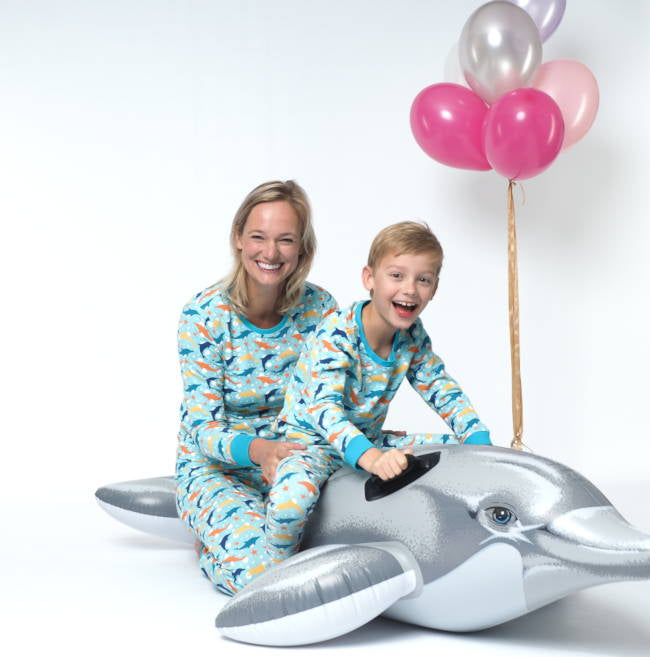 Mini me twinning pyjama, moeder met kind op een opblaas dolfijn in dezelfde pyjama.