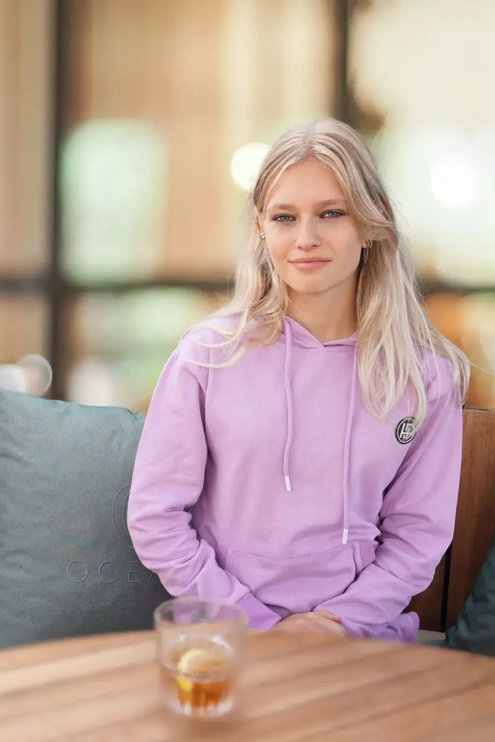Met een paarse joggingpak op de bank - jong blond model.